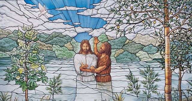 stained glass window of Jesus being baptised